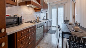 Una cucina moderna con forno a microonde, fornello e pensili in legno.