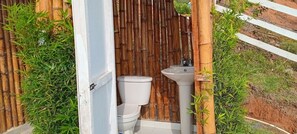 A bamboo-enclosed outdoor toilet with a white sink. - Glamping Isaju (Ginebra)