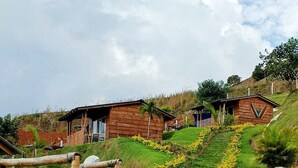 Paesaggio rurale con edifici in legno e un sentiero sterrato.