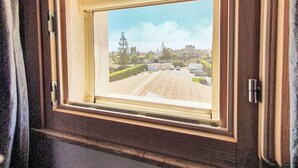 Una ventana enmarcada con vista a un estacionamiento y edificios.