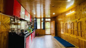 A kitchen with wooden walls, a stove, and cabinets.
