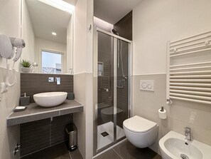 Regadera, secadora de cabello, bidet, toallas 