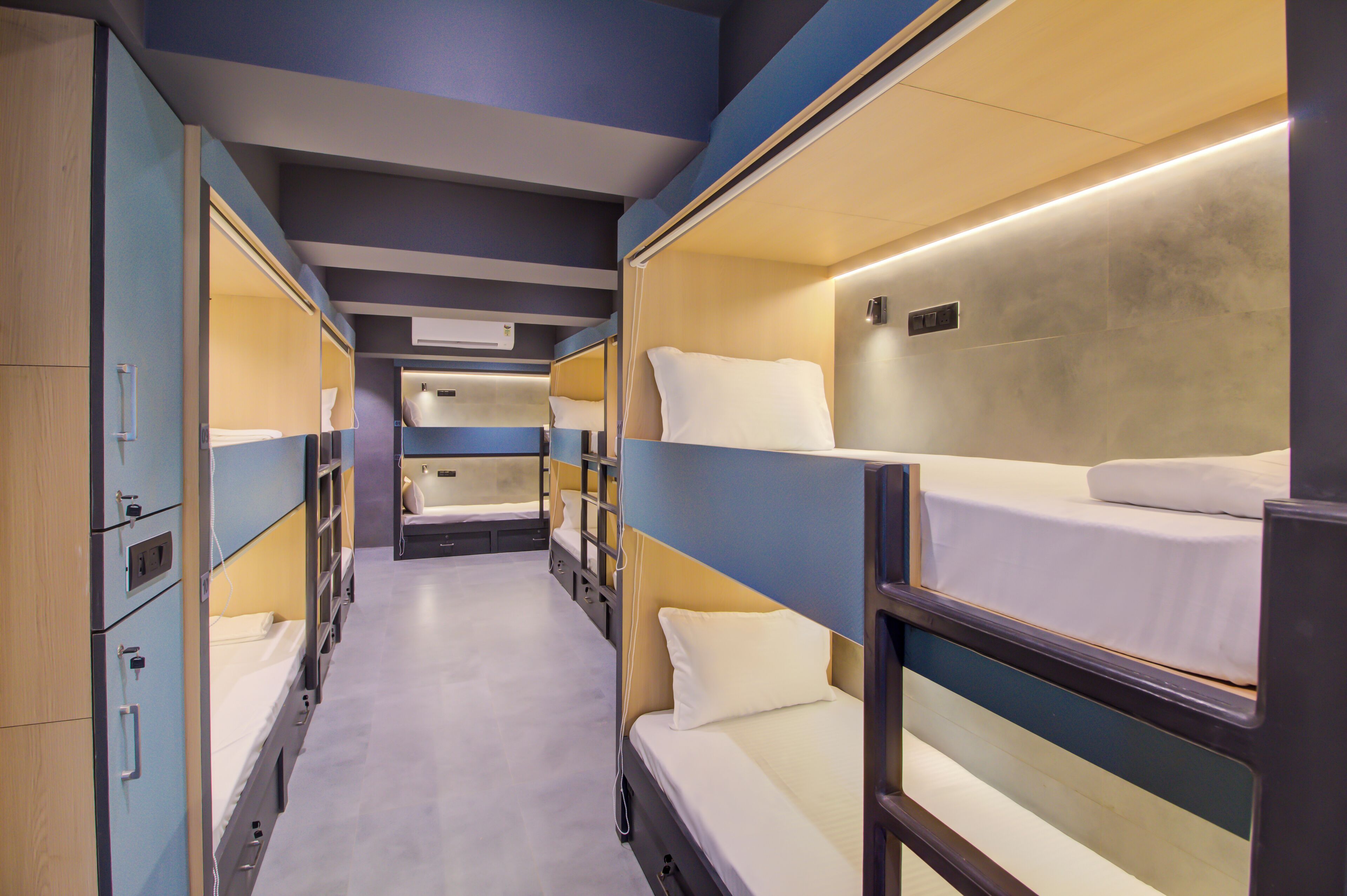 A train compartment with bunk beds, a central aisle, and overhead luggage racks.