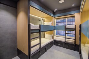 A train compartment with bunk beds, a small window, and a phone on the right side. - Mumbai Dorms (Mumbai)