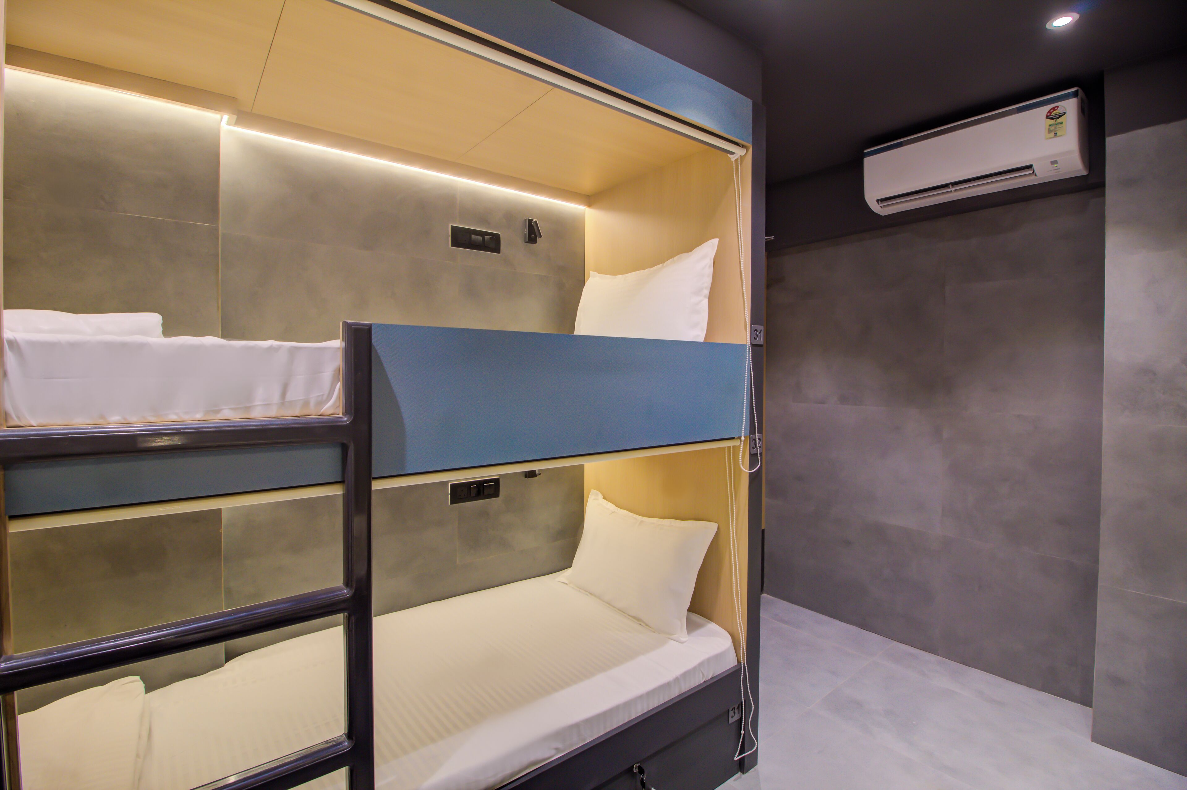 Dormitorio con literas, escritorio integrado y aire acondicionado de pared.