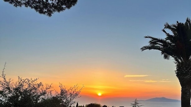 An outdoor dining table set for a meal with a sunset view. -  La Canostra Capri - luxury ROOM ad Anacapri (Anacapri)