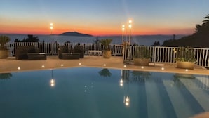 A swimming pool with a sunset view, surrounded by lounge chairs and potted plants. -  La Canostra Capri - luxury ROOM ad Anacapri (Anacapri)