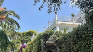 A two-story building with a stone archway leading to a covered walkway. -  La Canostra Capri - luxury ROOM ad Anacapri (Anacapri)