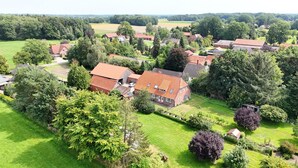 An aerial view of a residential area with houses, green lawns, and trees. - Fewo zum Königreich.... where others go on vacation  (Westerwalsede)