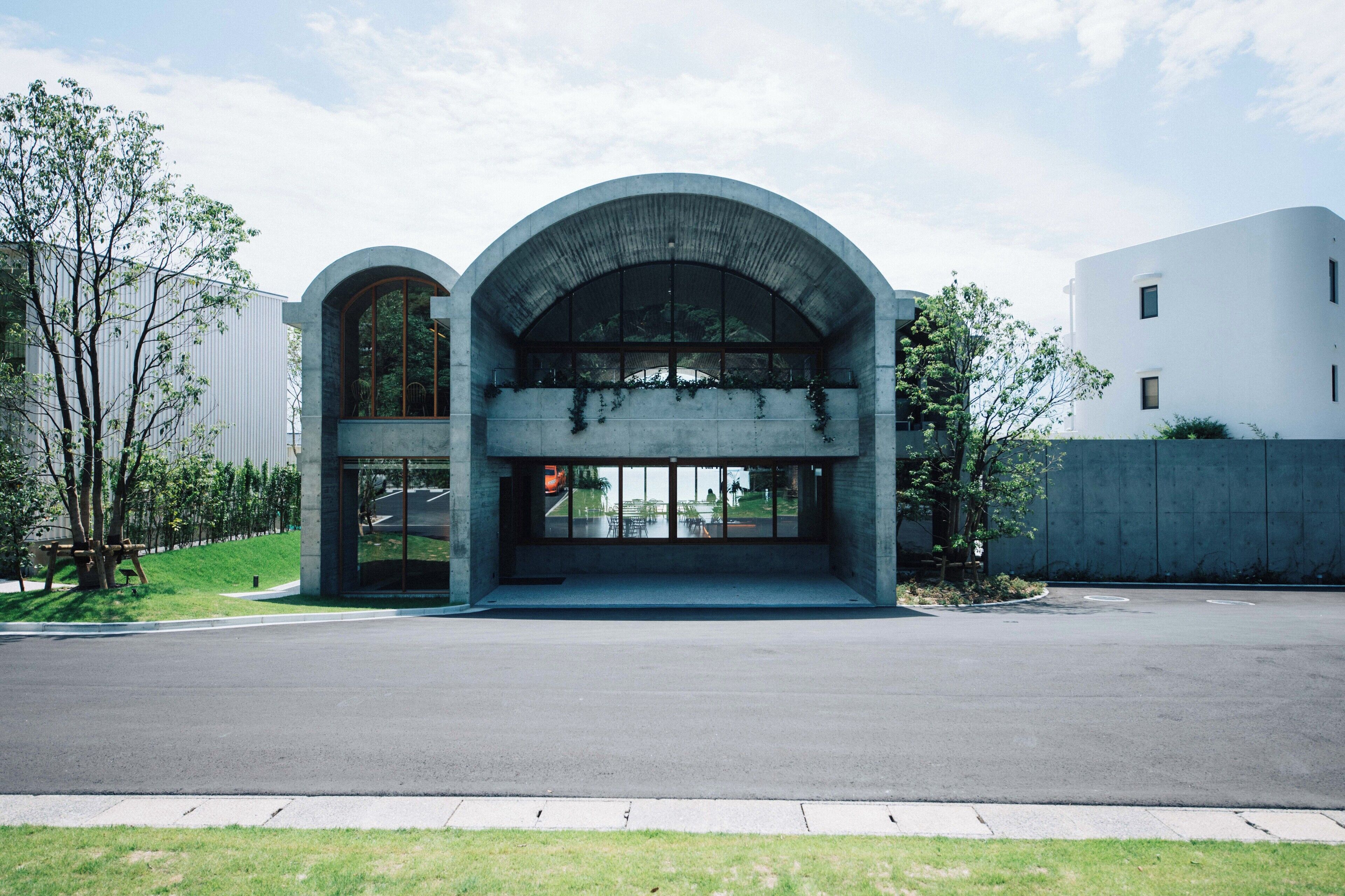 A modern building with a large arched entrance and a glass facade.