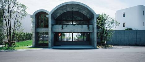 A modern building with a large arched entrance and a glass facade.