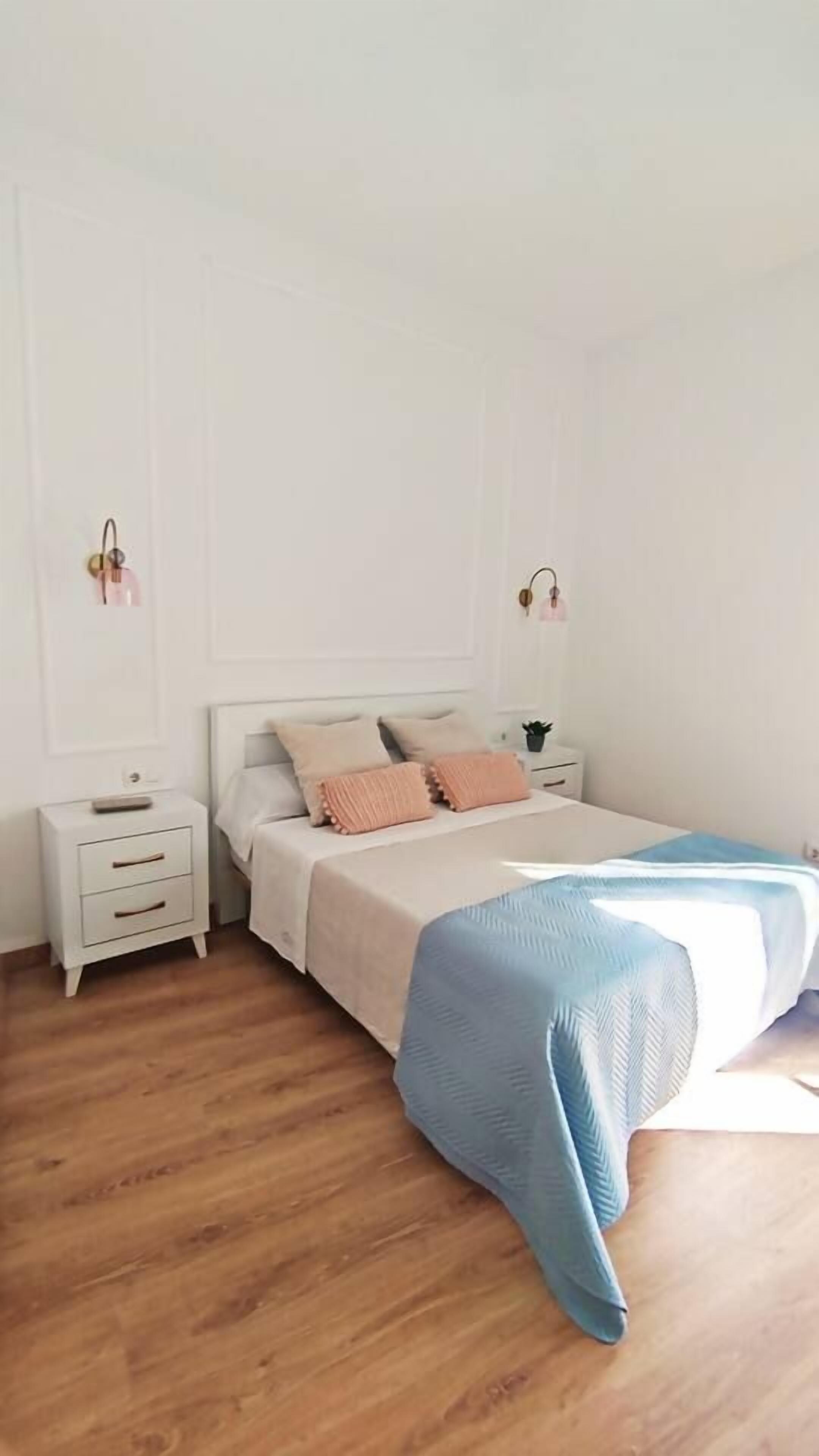 Une chambre à coucher avec un lit, des tables de chevet et une petite table à côté du lit.
