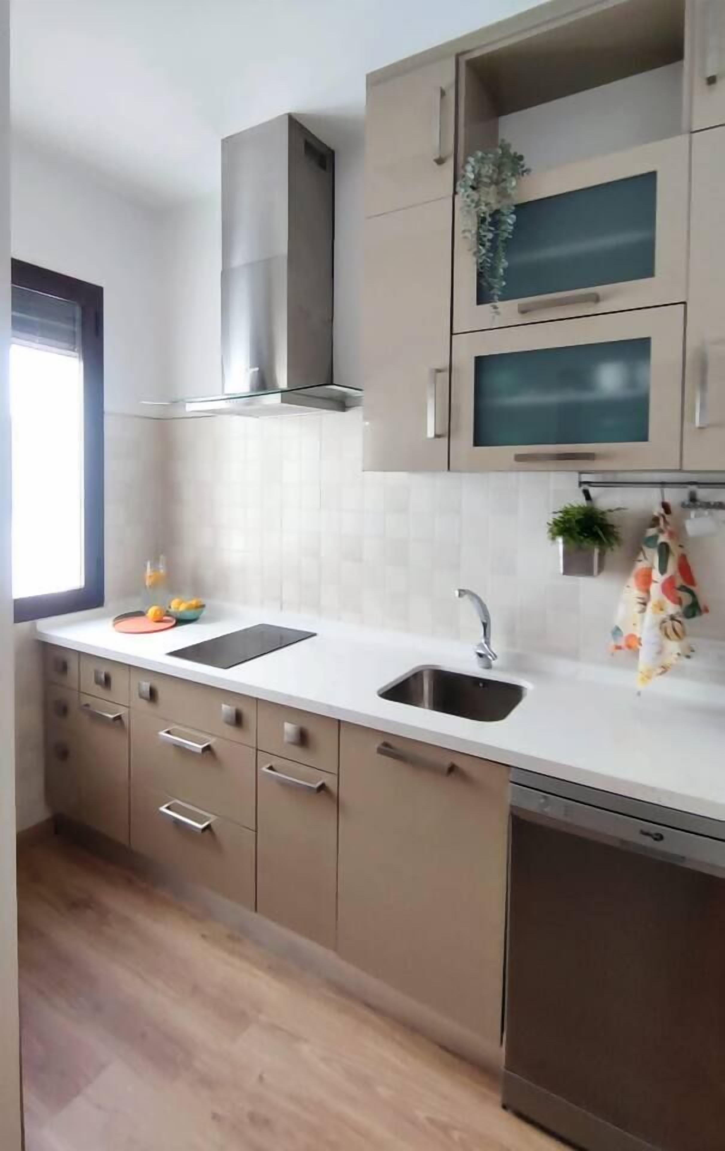 Una cucina moderna con lavello doppio, cappa aspirante in acciaio inossidabile e forno a microonde integrato.