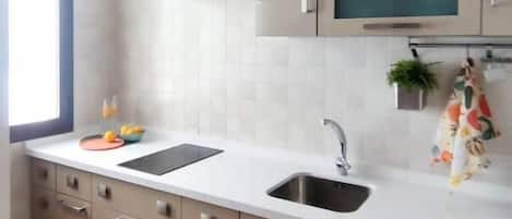 Una cucina moderna con lavello doppio, cappa aspirante in acciaio inossidabile e forno a microonde integrato.