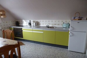 Enjoy cooking in this well-equipped kitchen with a stainless steel sink, oven, and refrigerator.