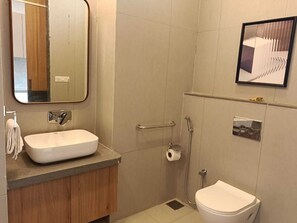 A bathroom with a sink, toilet, and shower.