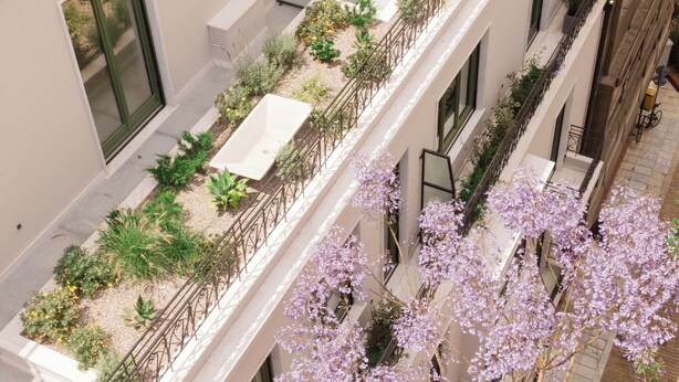 A rooftop garden with a rectangular planter, a dining area with a table and chairs, and a balcony with a railing. - Athens Capital Suites-Mgallery Collection (Athens)