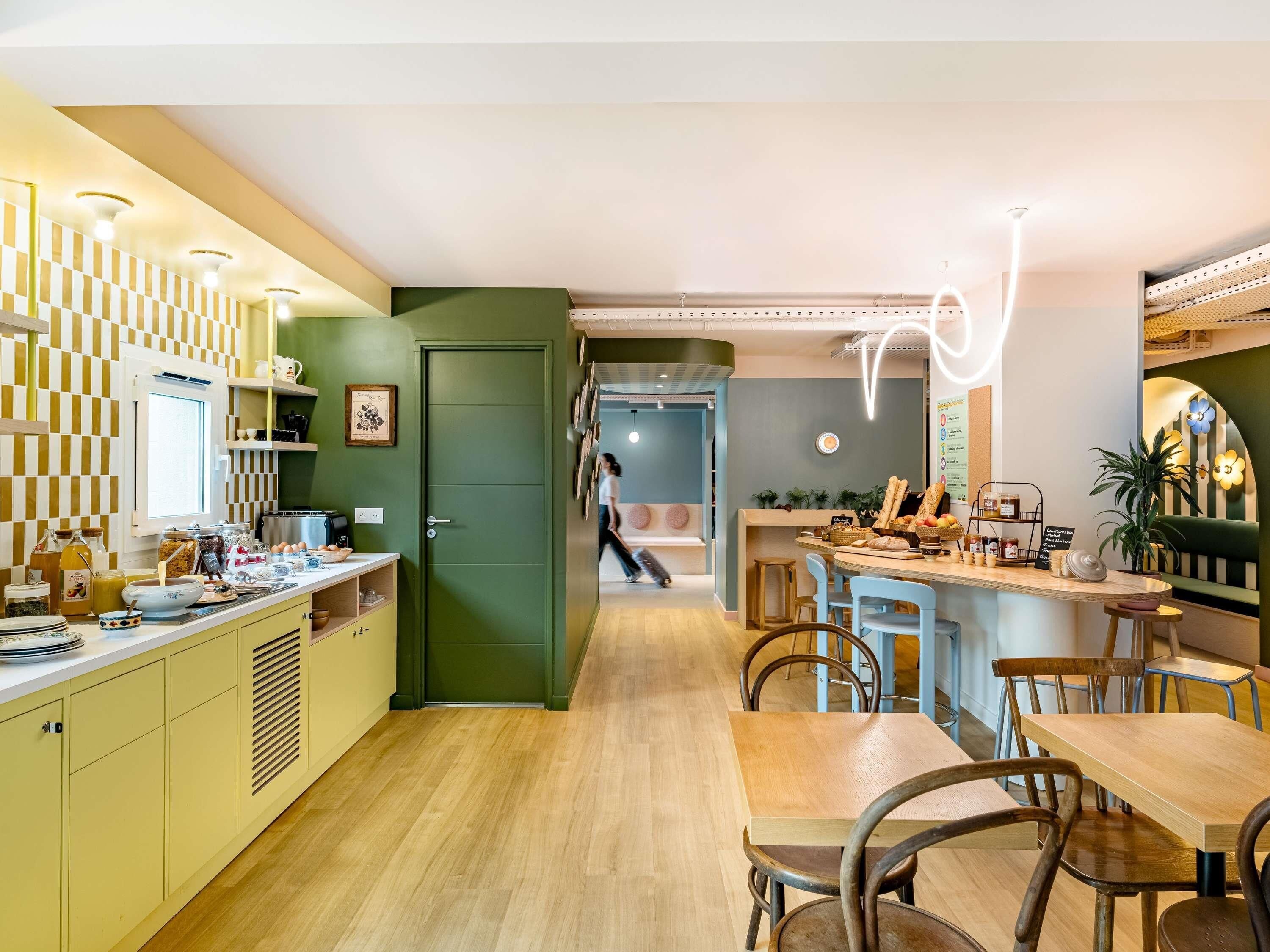 Une cuisine moderne avec une porte verte, des meubles en bois et un bar pour prendre le petit-déjeuner.