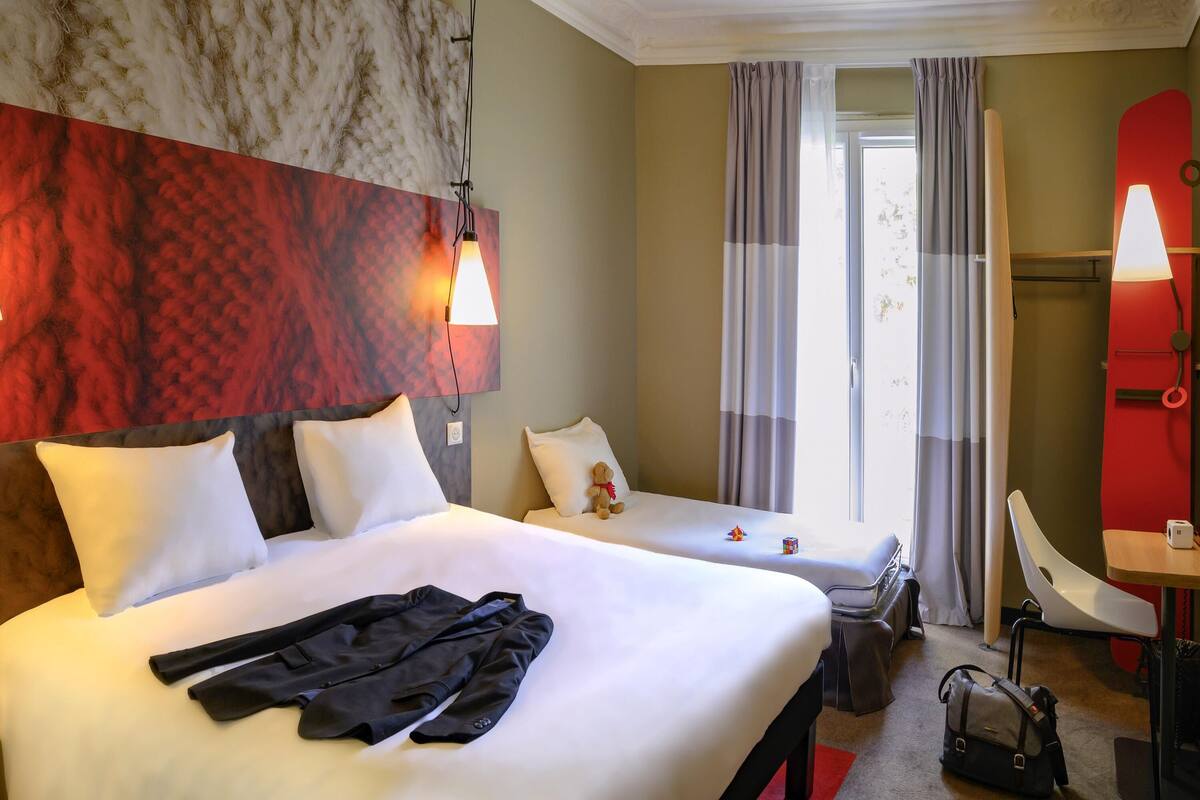 Una habitación de hotel con dos camas, un escritorio y una silla.