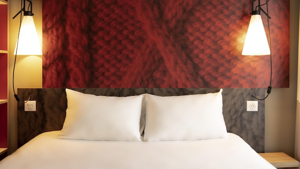 A hotel room with a large bed, two bedside lamps, and a red textured wall above the bed. - Ibis Paris Tour Montparnasse 15Ème (Paris)