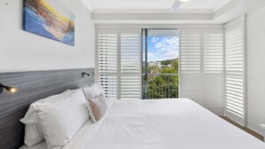 Una camera da letto con un letto, una ventola a soffitto, un quadro e vista dalla finestra.