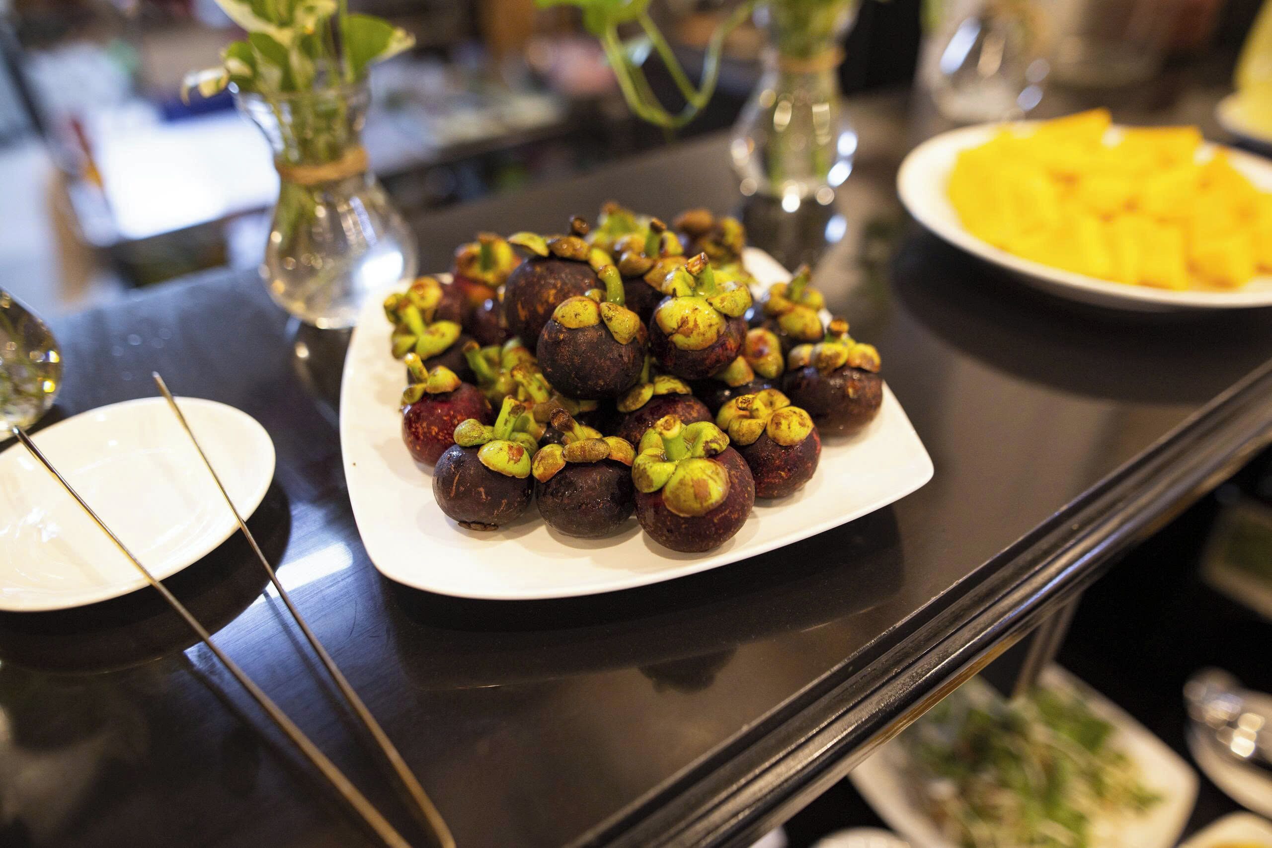 A table with a plate of stuffed figs and a plate of pineapple chunks.