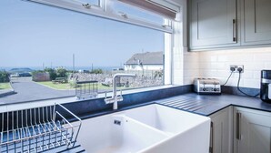 Una cucina con un'ampia finestra, un lavello e uno scolapiatti.