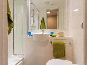A modern bathroom with a glass shower enclosure, a white sink, and a toilet. - Student Only Calico (Liverpool)