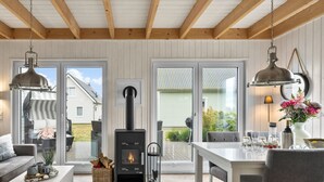 En hyggelig stue med pejs, sofa, spisebord og udsigt ud
