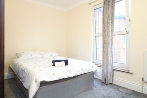 A bedroom with a bed, a window, and a radiator. - Centrally located double room (Southampton)