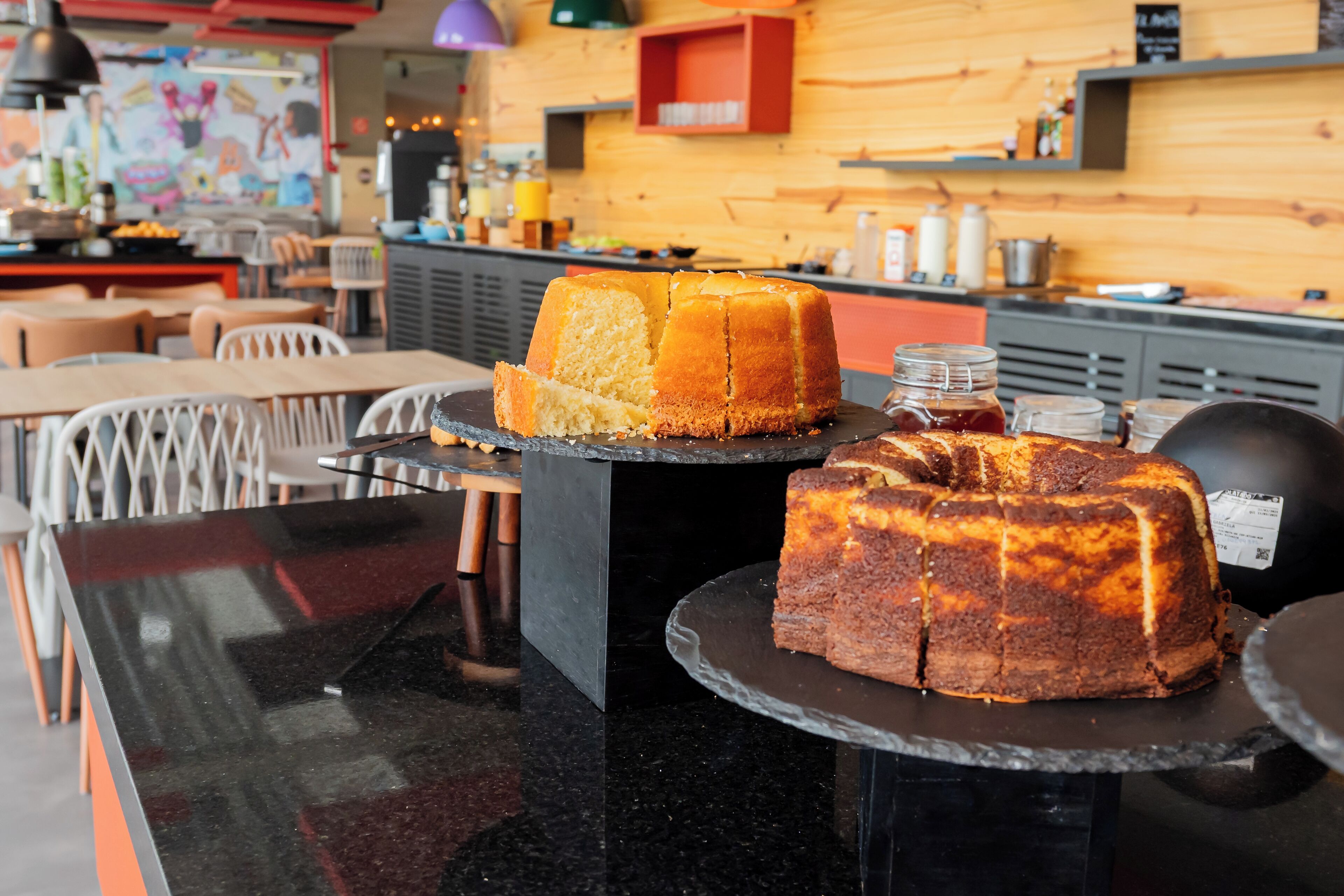Una encimera de cocina con dos pasteles expuestos.