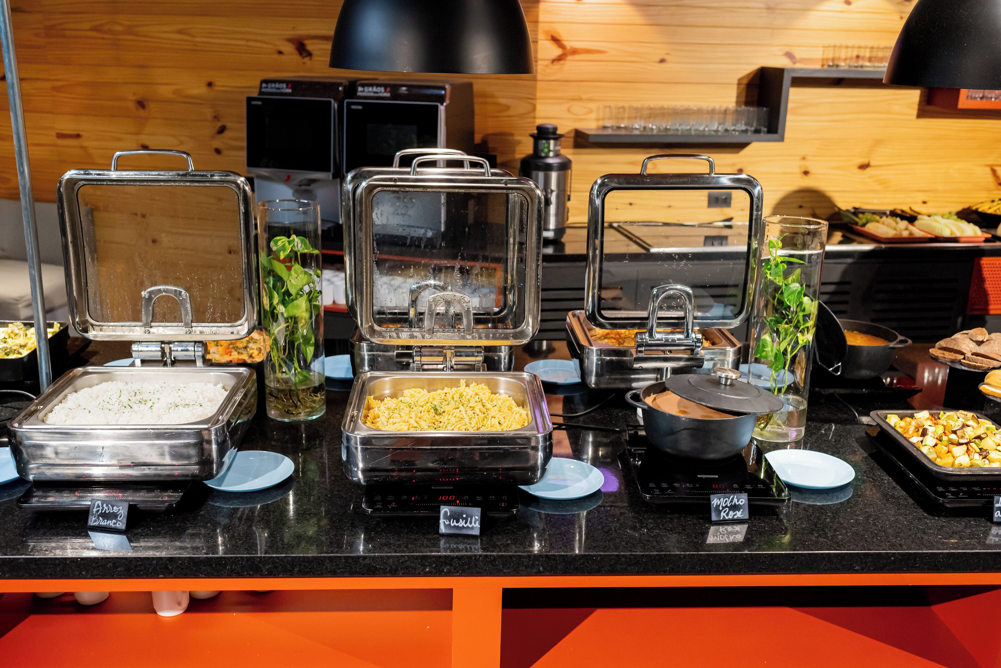 A buffet with various food items and a coffee machine.