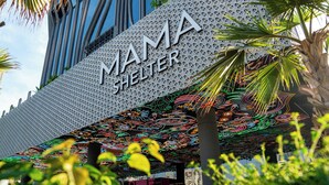 Exterior do edifício Mama Shelter, com fachada geométrica marcante e um mural colorido.