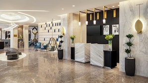A modern lobby with a marble floor, seating area, reception desk, and decorative wall panels. - Mercure Riyadh Al Anoud (Riyadh)
