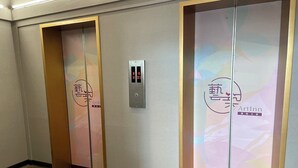 Twee liftdeuren met een digitaal display en een logo.