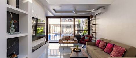 A modern living room with a sofa, coffee table, and shelves.