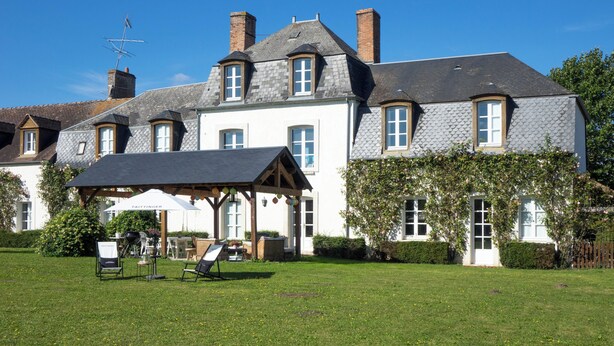 A large, two-story house with a covered patio, multiple chimneys, and a well-maintained lawn. - Domaine de Bel Ebat offers a peaceful, green setting (1h from Paris) (Paucourt)