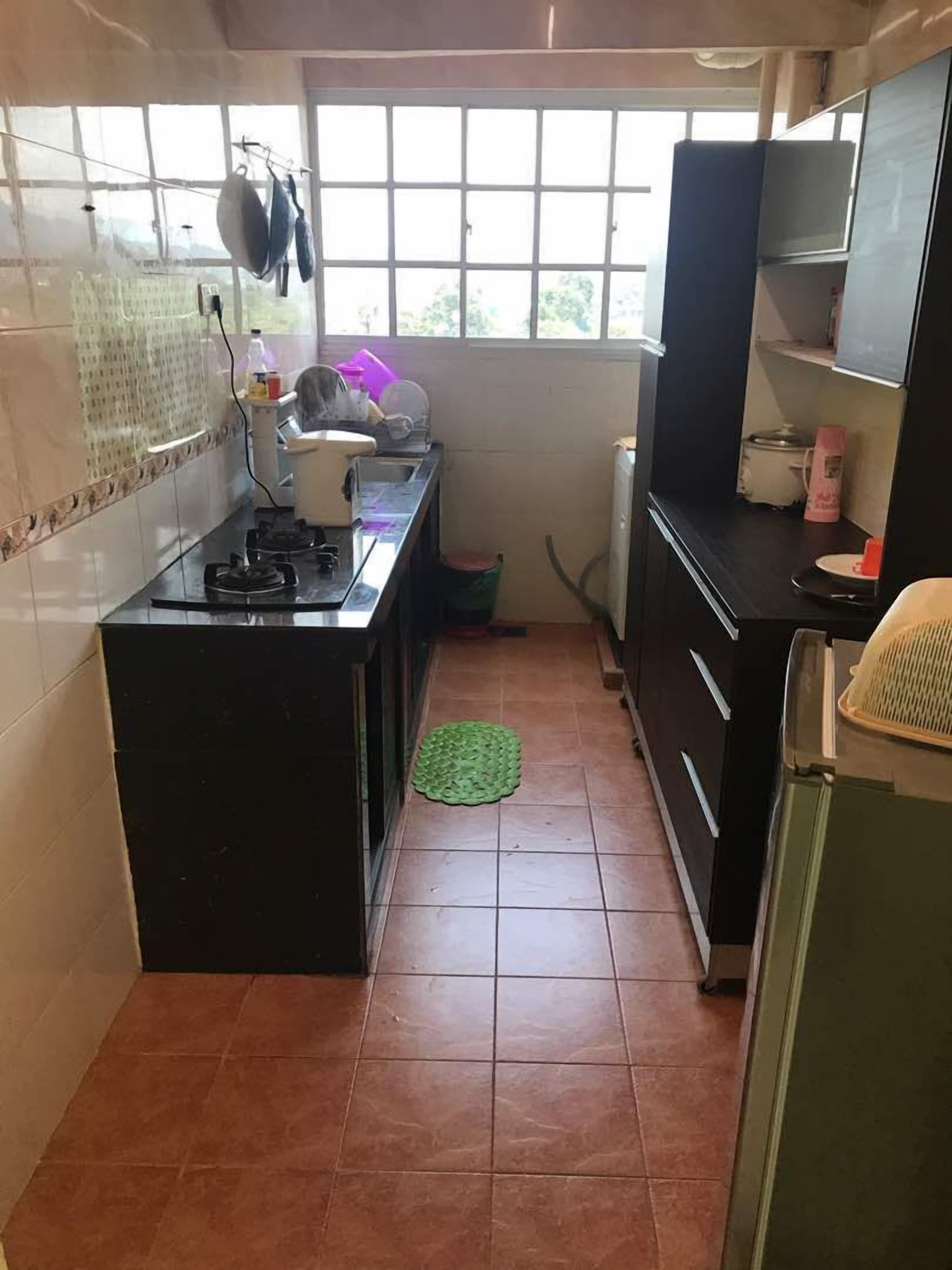 A compact kitchen with a gas stove, a sink, and a window providing natural light.