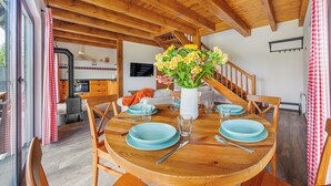 A wooden dining table set with blue plates and a vase of flowers.