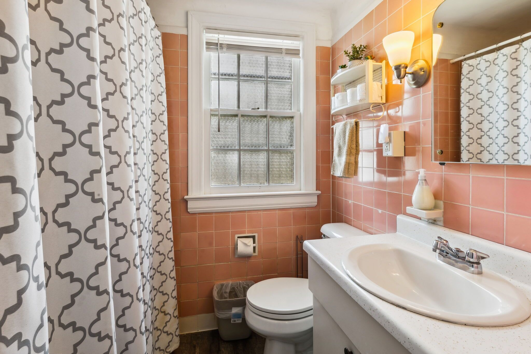Une salle de bain avec des toilettes, un lavabo et une fenêtre.
