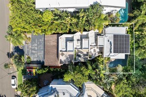 An aerial view of a residential property with multiple buildings, a swimming pool, and surrounding greenery. - Little Cove Haven - Naousa 4 with Rooftop deck (Noosa)