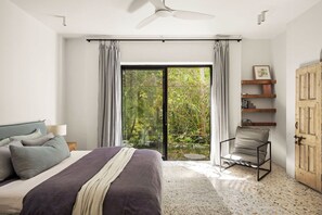 A bedroom with a bed, a chair, a ceiling fan, a window with curtains, and a door. - Mykonos Luxury Villa at Sunshine Beach (Noosa)