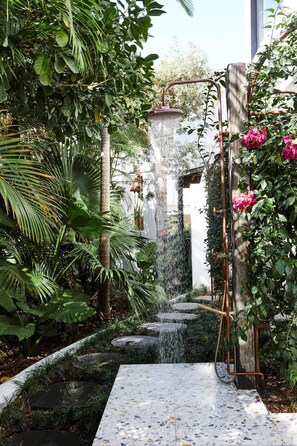 A garden with a water feature, stone steps, and lush greenery. - Mykonos Luxury Villa at Sunshine Beach (Noosa)