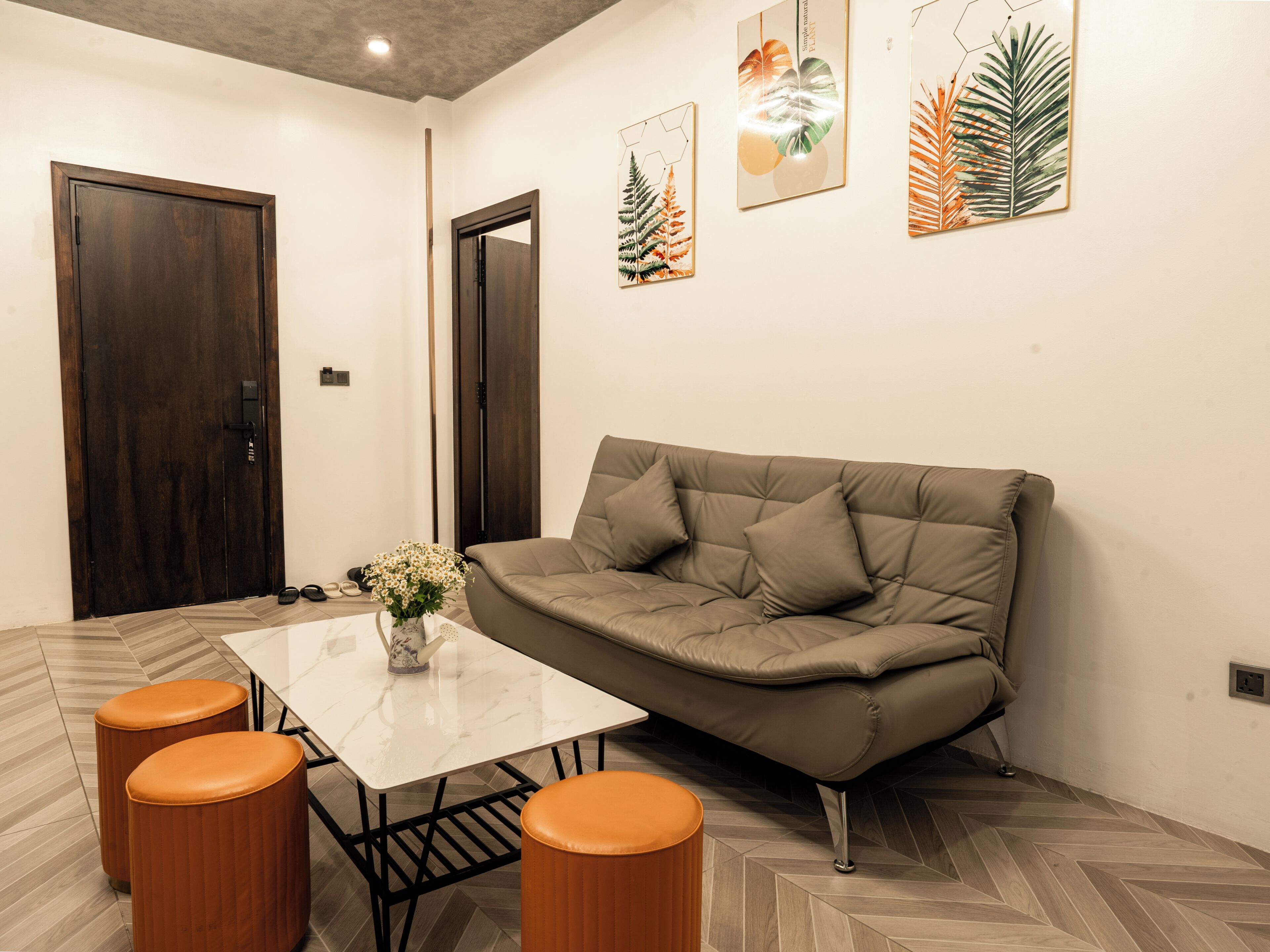 A modern living room with a sofa, a coffee table, and two ottomans.