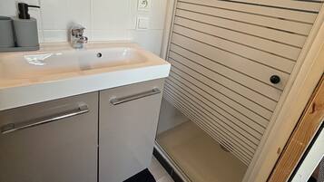 Chuveiro, toalhas de banho, sabonete, papel higiênico