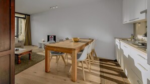 Una cocina moderna con armarios blancos, una mesa de comedor de madera y una isla de cocina.