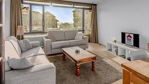 Una sala de estar moderna con un sofá, una mesa de centro y un televisor.