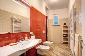 Ein Badezimmer mit Doppelwaschbecken, Toilette und Duschbereich.