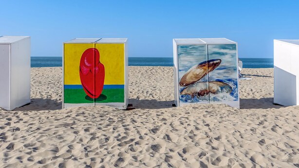 Drei Kunstinstallationen am Strand mit freiem Blick auf das Meer.