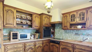 A kitchen with wooden cabinets, a microwave, an oven, and a dishwasher.
